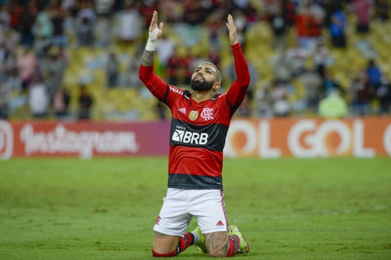 Imagem com foto do jogador Gabigol ajoelhado em campo durante partida contra o Bahia