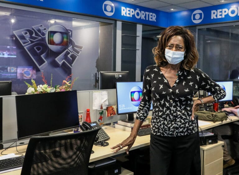 Imagem com foto da jornalista Glória Maria na redação do Globo Repórter