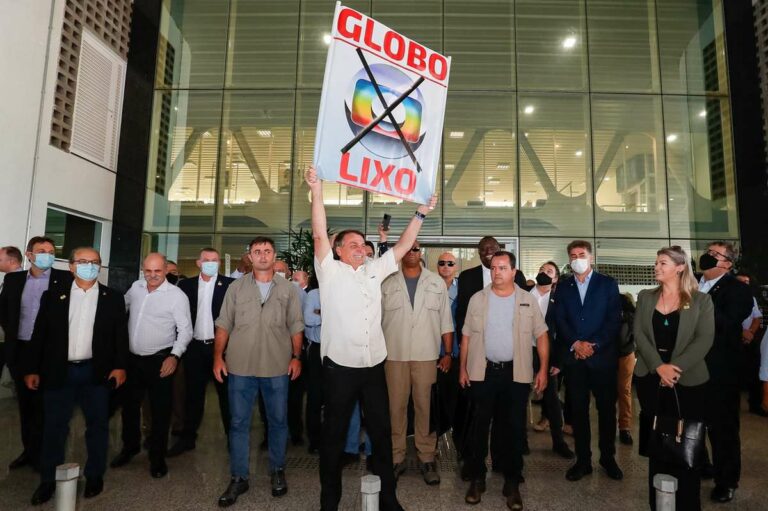 Imagem com foto do presidente Jair Bolsonaro segurando uma placa com a frase Globo lixo