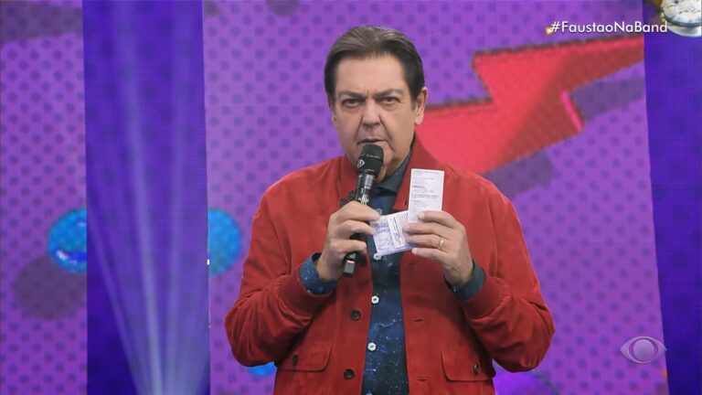 Foto do apresentador Faustão, com um casaco vermelho, nos estúdios da Band