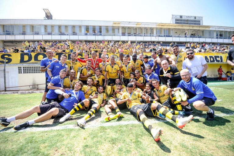 Imagem com foto do time do São Bernardo, atual campeão da Copa Paulista, recebendo o troféu