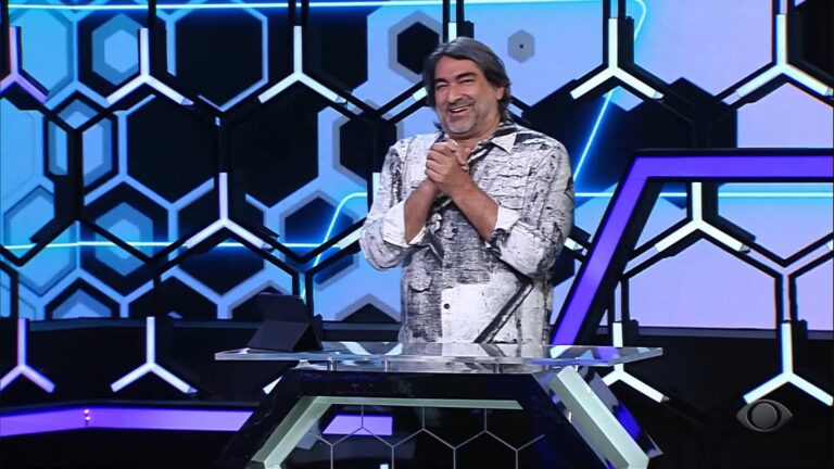 Foto do apresentador Zeca Camargo rindo no cenário de 1001 Perguntas