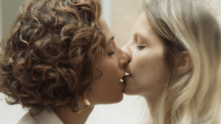 Imagem com foto do momento em que Olga (Camila Pitanga) e Ivona (Elisa Volpatto) se beijam na série Aruanas. Globo censurou cena na TV aberta