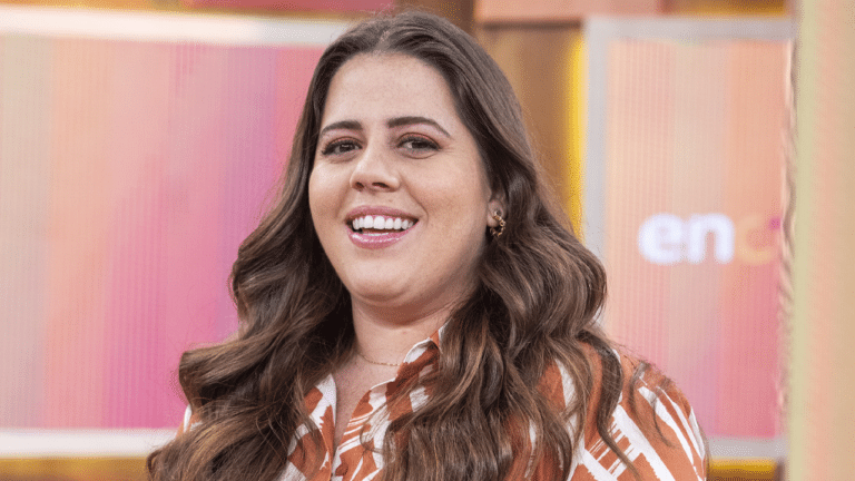 Tati Machado aparece sorridente em foto no cenário do programa Encontro