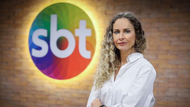 Luciana Valerio em foto com logo do SBT ao fundo