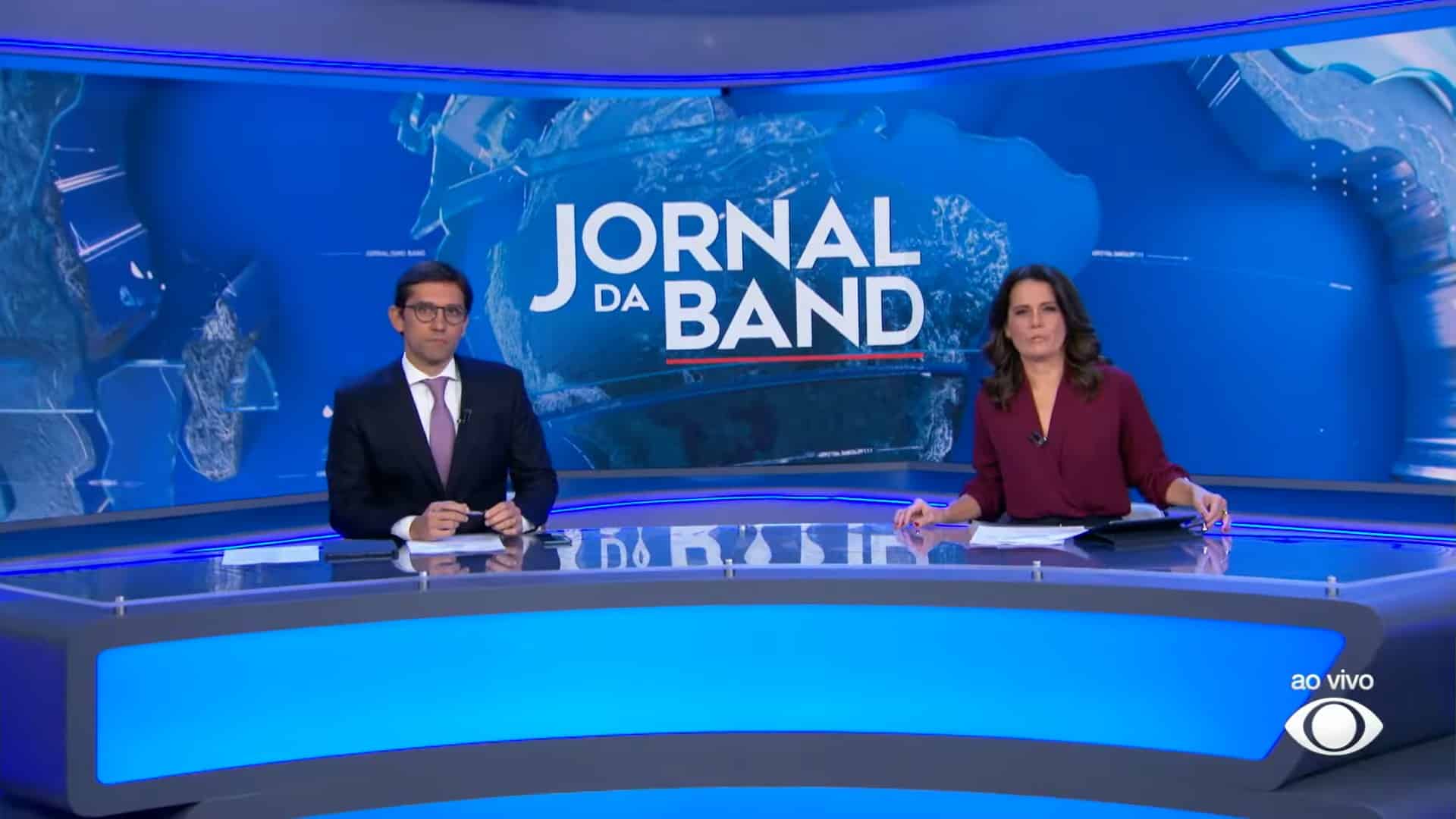 Foto de Rodolfo Schneider e Adriana Araújo na bancada do Jornal da Band