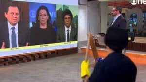 Foto de Marcelo Cosme no palco de programa da GloboNews e faxineira na frente da câmera