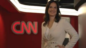 Foto de Clarissa Oliveira em frente ao logo da CNN Brasil