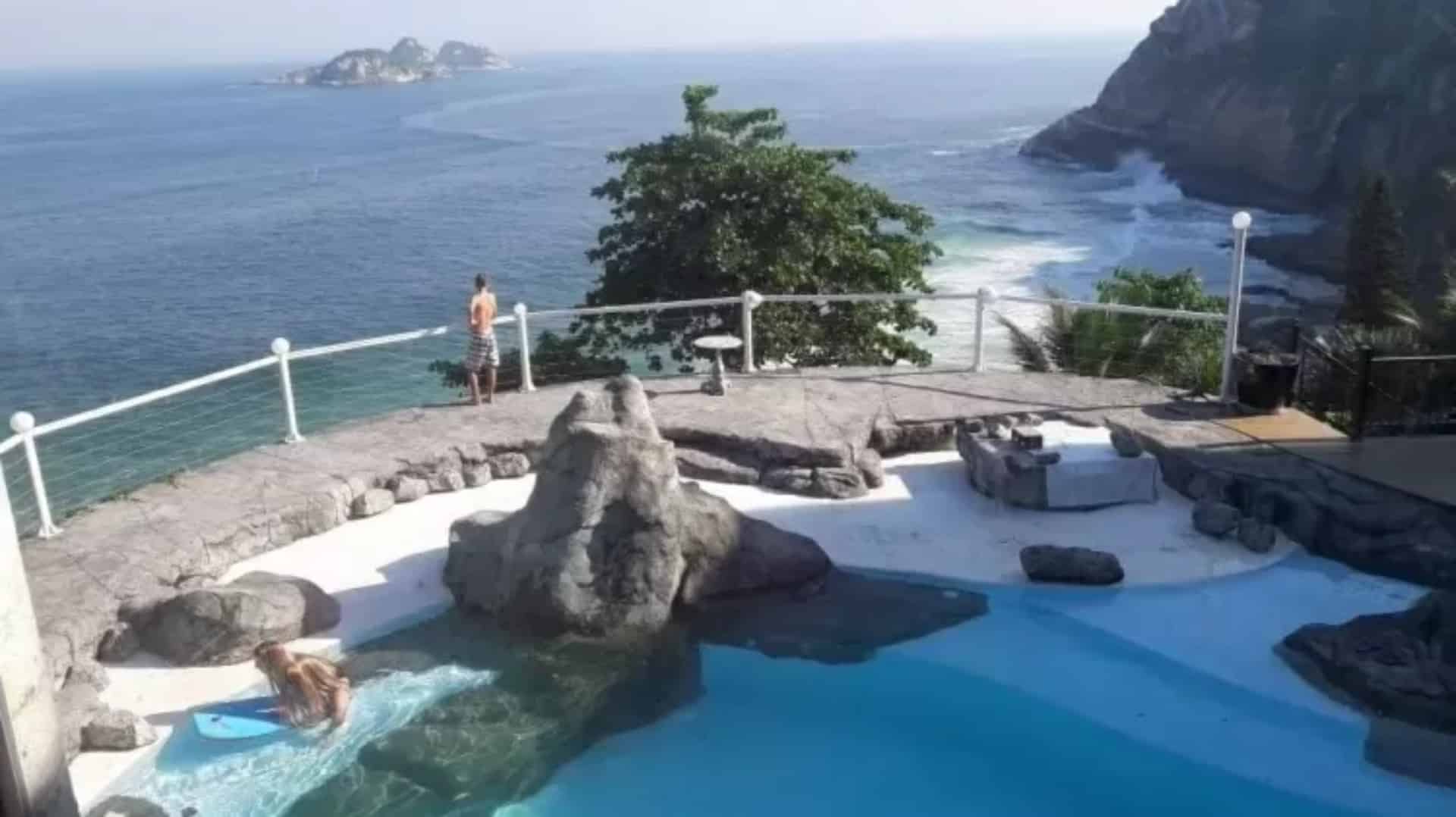 Foto de vista de piscina com mar para o fundo