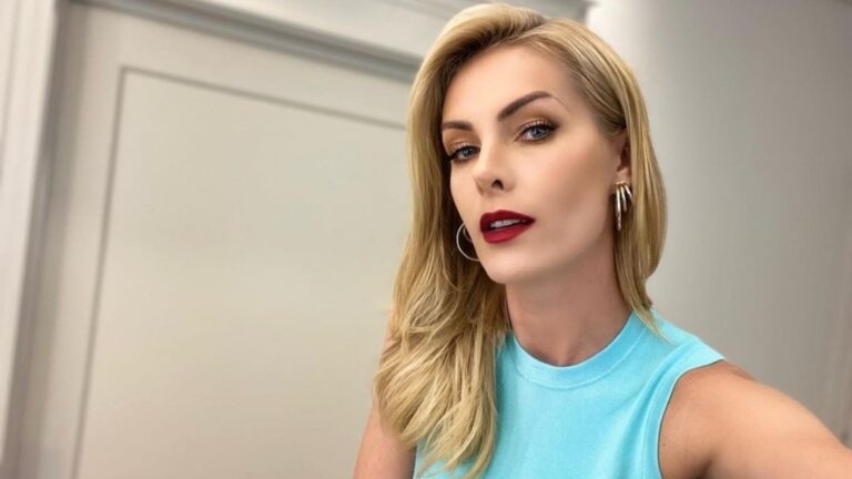 Foto de Ana Hickmann de batom vermelho escuro e blusinha azul claro