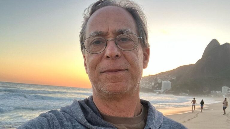 Foto de Pedro Cardoso na praia de Ipanema com Morro Dois Irmãos no fundo