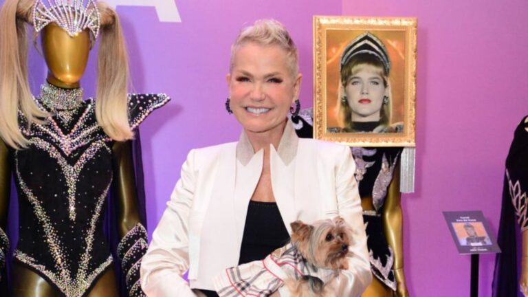 Foto de Xuxa Meneghel sorrindo e segurando a cachorra Doralice