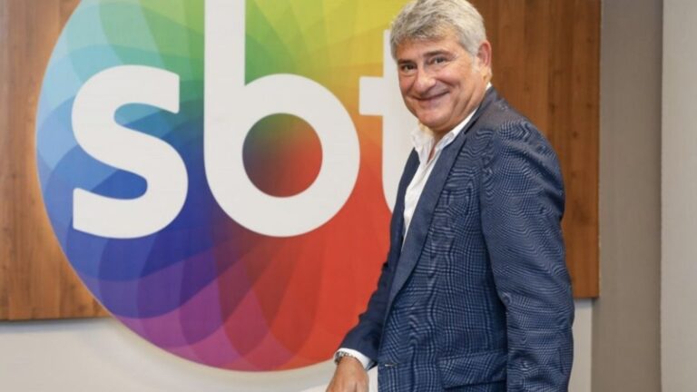 Foto de Cléber Machado em frente a logo do SBT