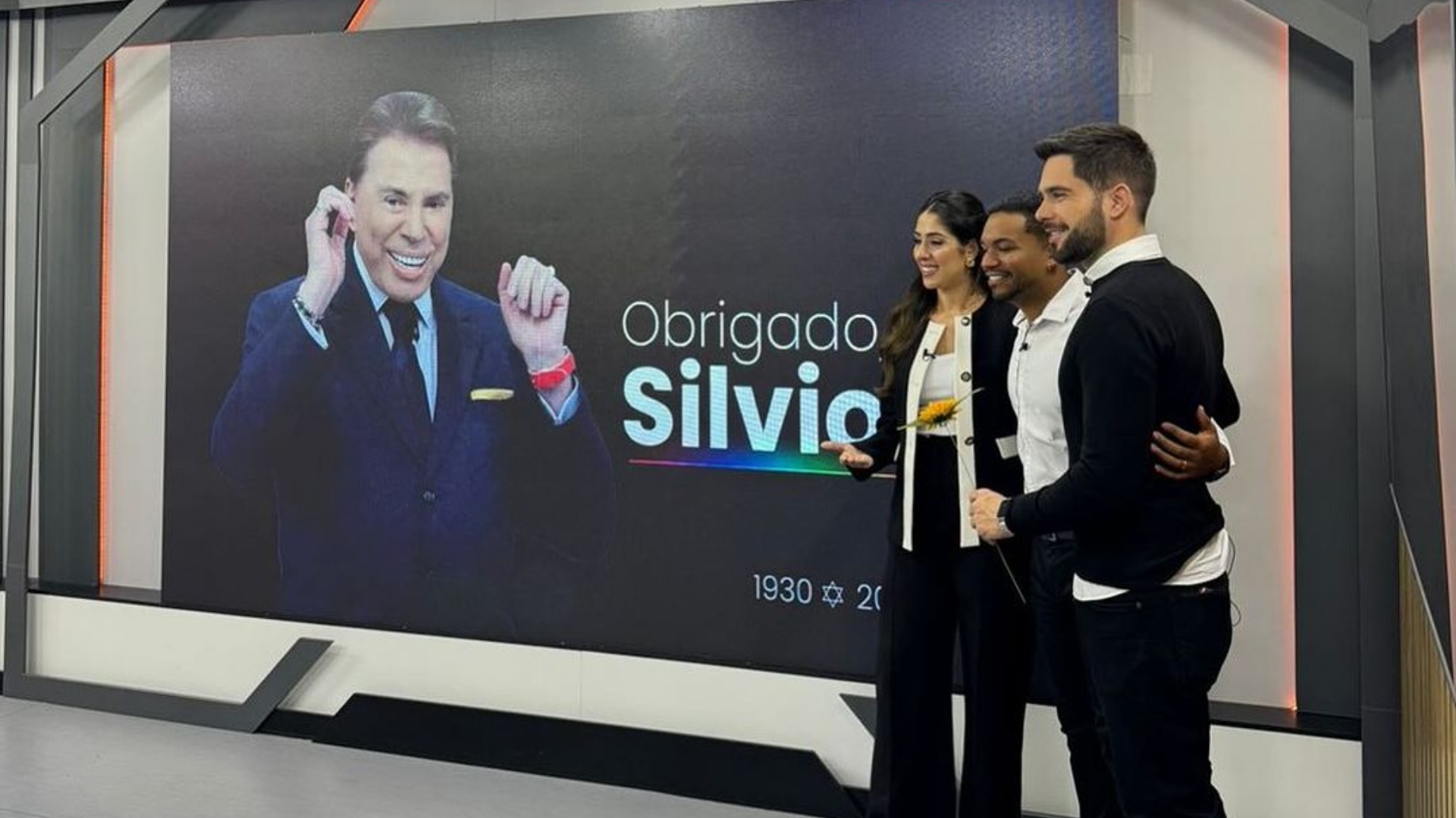 Foto de Gabriela Abravanel e outros dois apresentadores abraçados em homenagem a Silvio Santos