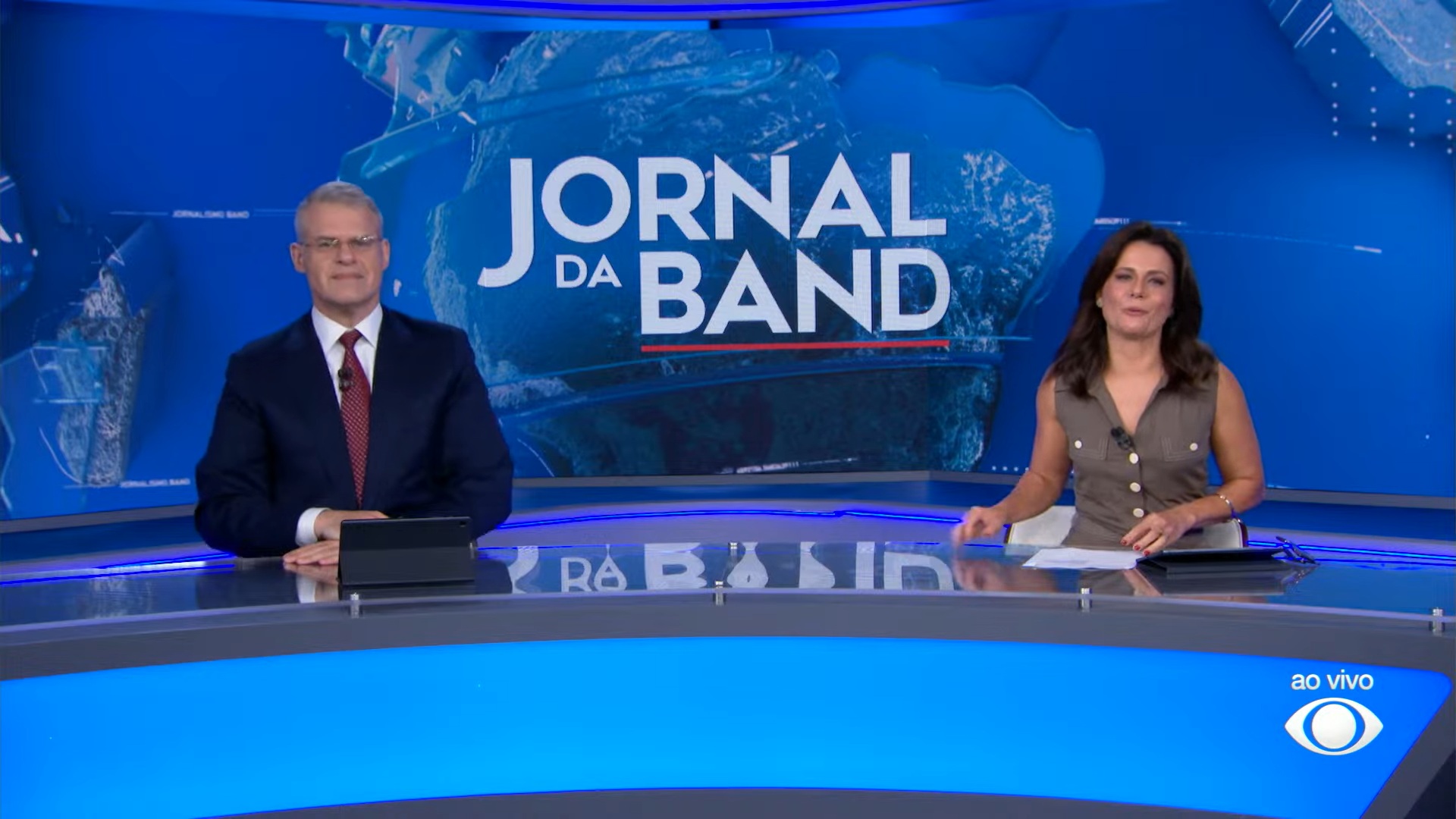 Imagem de Eduardo Oinegue e Adriana Araújo na bancada do Jornal da Band