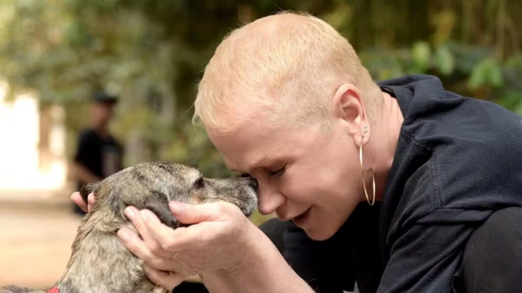 Foto de Xuxa Meneghel segurando cachorrinho pelo rosto