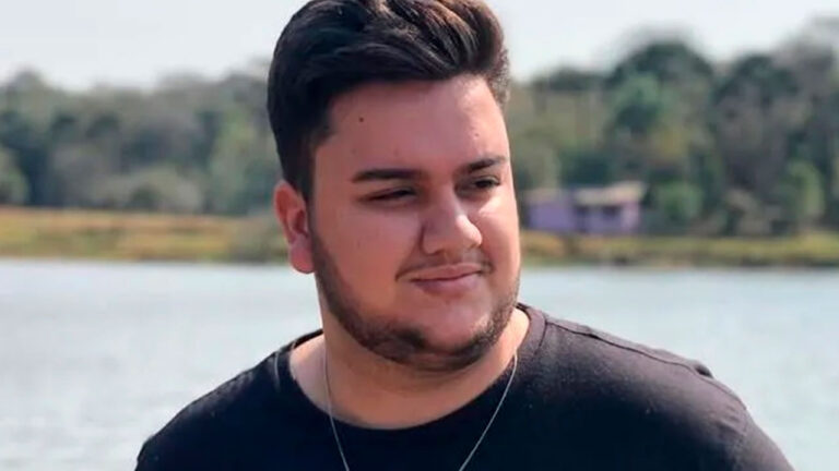Cezar Filho posa ao ar livre com rio e vegetação ao fundo