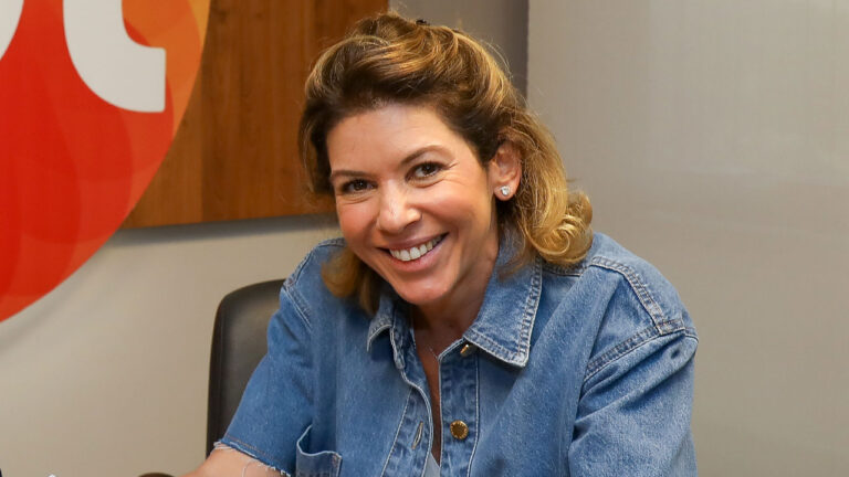 Daniela Beyruti sorrindo durante reunião nas dependências do SBT
