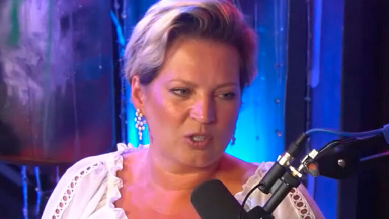 Joice Hasselmann durante entrevista no podcast Inteligência Ltda, falando ao microfone com cenário azul ao fundo