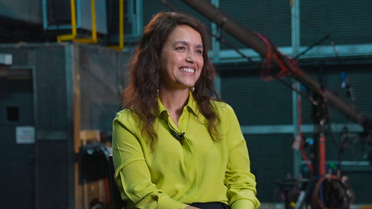 Manuela Dias sentada em estúdio durante gravação de conteúdo sobre o remake de Vale Tudo
