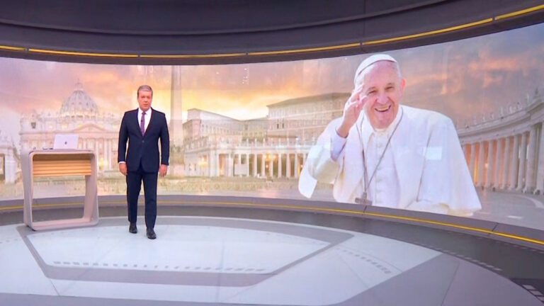 Roberto Kovalick no estúdio do Jornal Hoje com imagem do Papa Francisco e da Praça São Pedro ao fundo durante a programação da Globo