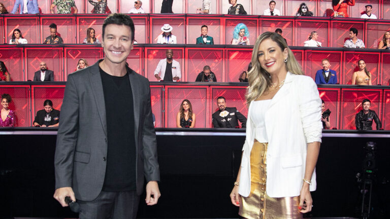 Rodrigo Faro e Ticiane Pinheiro no palco do Canta Comigo Teen, com jurados posicionados nas cabines ao fundo