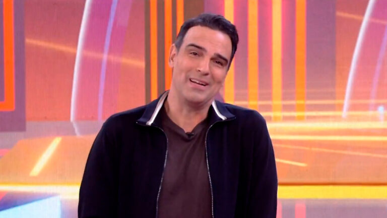 Tadeu Schmidt durante apresentação do BBB 25 com painel colorido ao fundo no estúdio da TV Globo