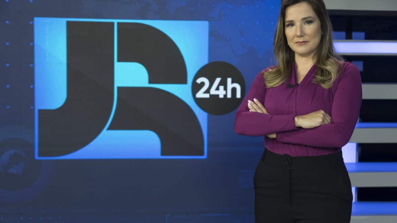 Imagem da jornalista Adriana Perroni no cenário do Jornal da Record