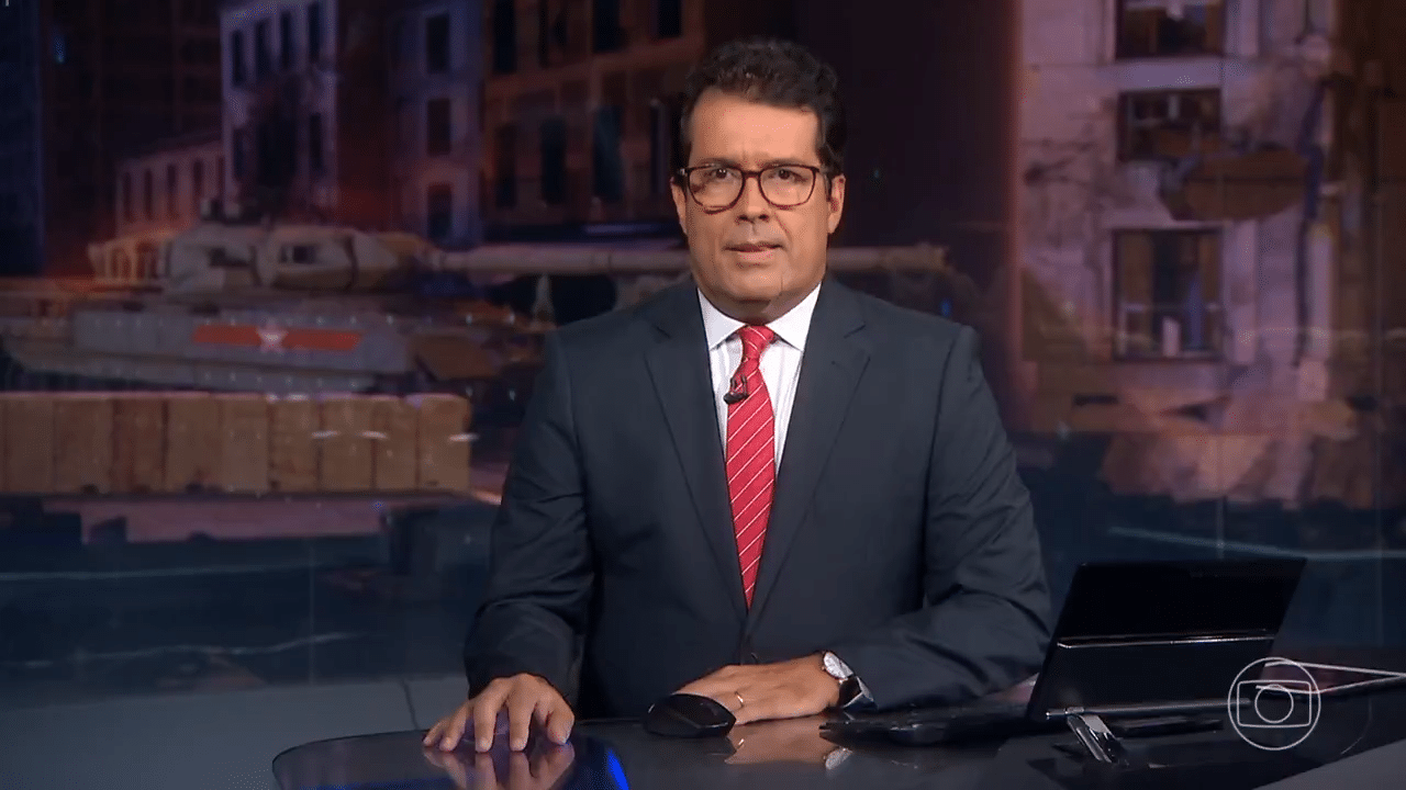 Imagem com foto do jornalista André Trigueiro durante apresentação do Jornal Nacional