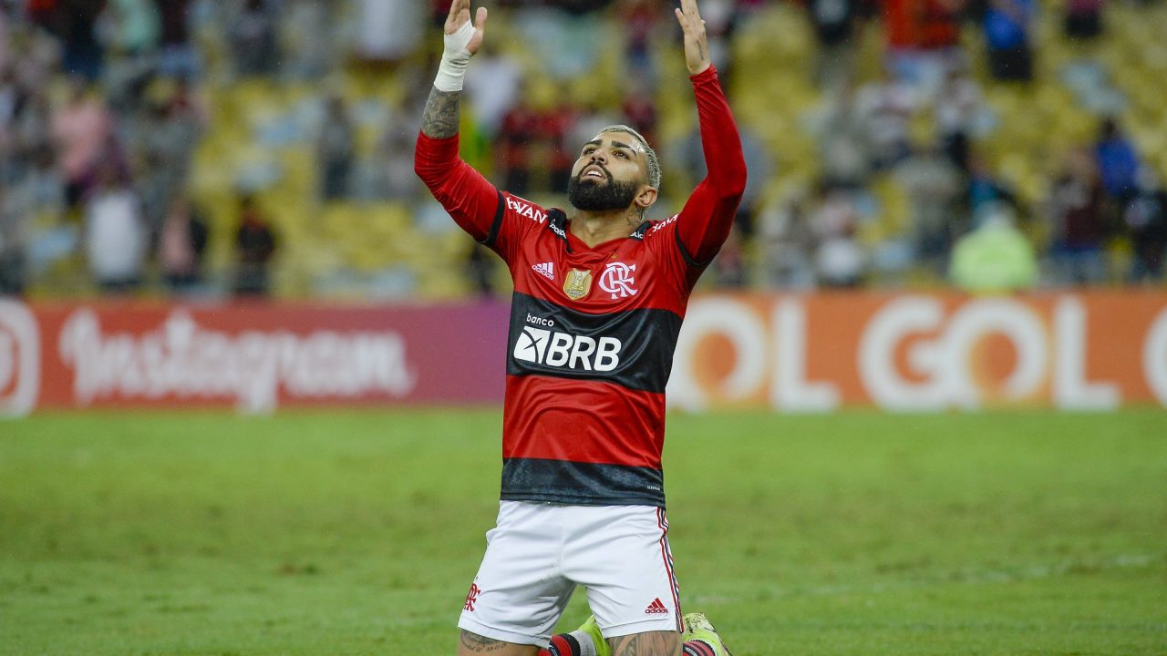 Imagem com foto do jogador Gabigol ajoelhado em campo durante partida contra o Bahia