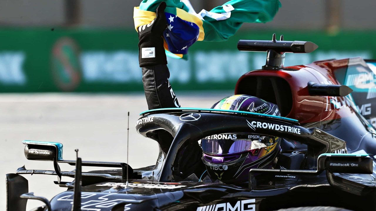 Imagem com foto de Lewis Hamilton com a bandeira do Brasil