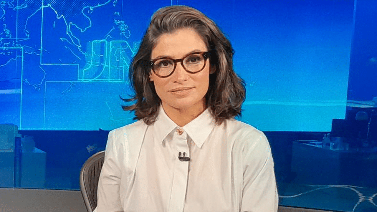 Imagem com foto da apresentadora Renata Vasconcellos na bancada do Jornal Nacional