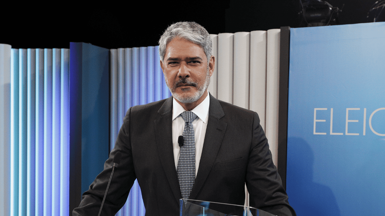 Imagem com foto de William Bonner no cenário do debate da Globo