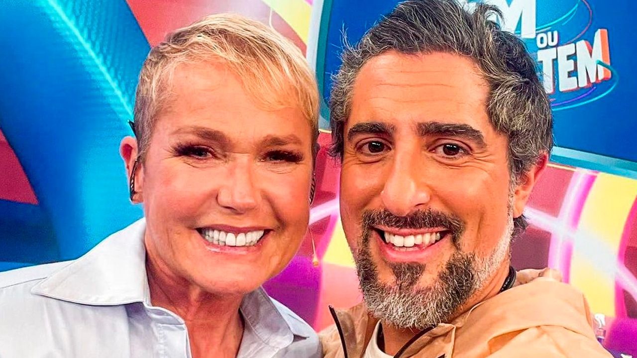 Imagem com foto de selfie de Xuxa e Marcos Mion no palco do Caldeirão