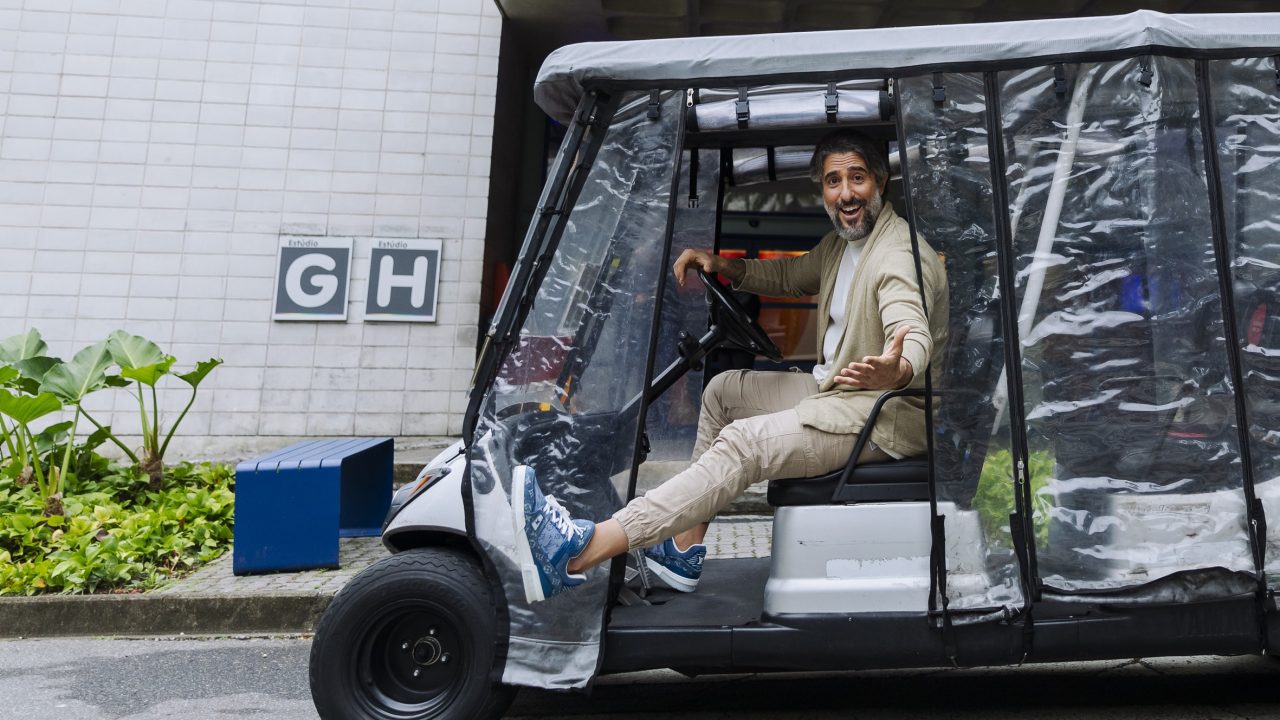 Imagem com Marcos Mion em um dos carrinhos de transporte de pessoas dos Estúdios Globo