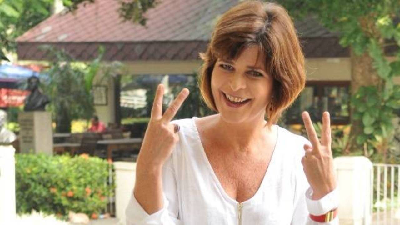 Cristianne Fridman fazendo sinal de vitória com as mãos em foto