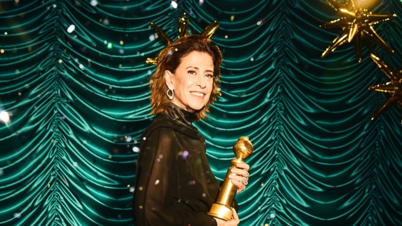 Foto de Fernanda Torres segurando prêmio Globo de Ouro