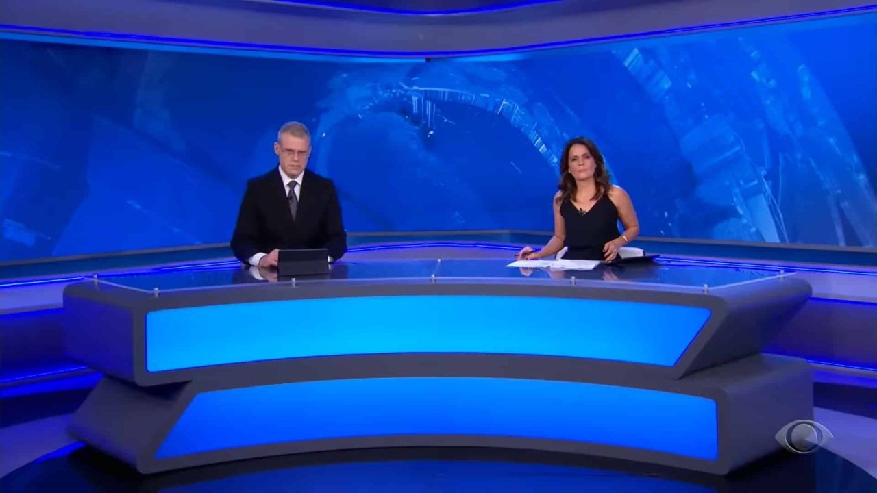 Foto dos jornalistas Eduardo Oinegue e Adriana Araújo na bancada do Jornal da Band