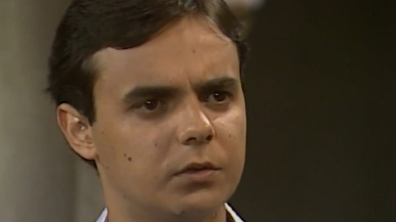 A imagem mostra Ricardo, personagem da novela Tieta, exibida pela TV Globo em 1989. Ele aparece com uma expressão séria e um olhar atento, sugerindo preocupação ou surpresa diante de uma situação