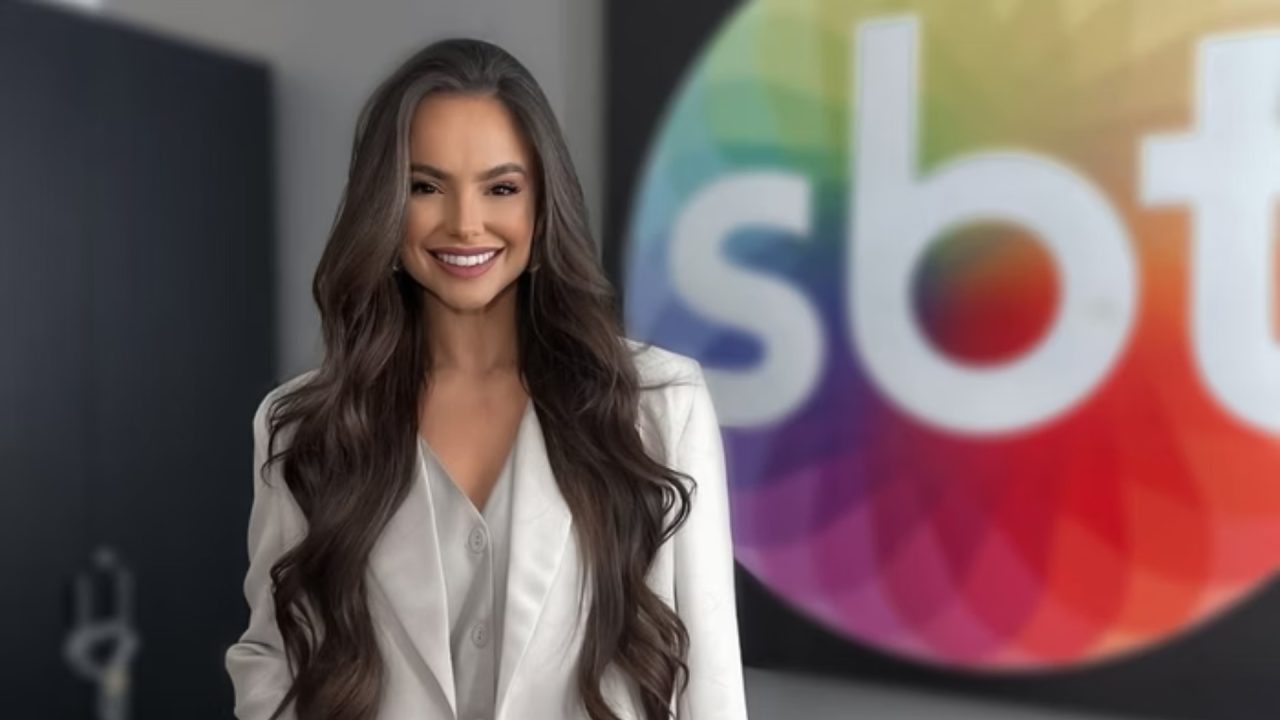 Foto de Suzana Busanello em frente ao logo do SBT