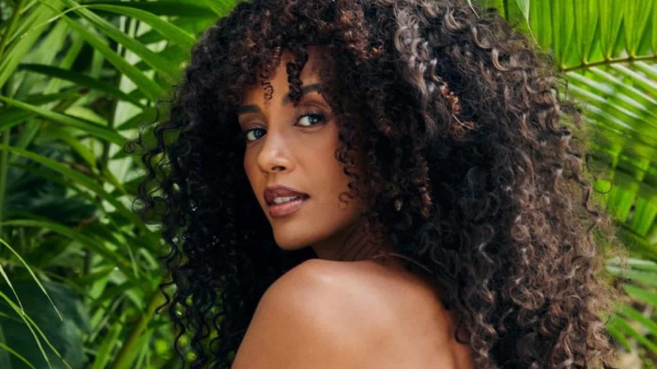 Foto de Taís Araujo com cabelo cacheado muito volumoso e franja